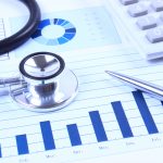 Financial statement with stethoscope and calculator