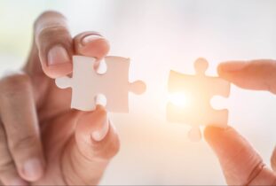 Business solutions, success and strategy concept. Businessman hand connecting jigsaw puzzle.