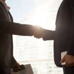 Business handshake, two businessmen shaking hands, partnership concept, close up