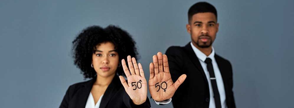 Shot of businessman and businesswoman advocating for gender equality against a grey studio background