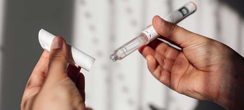 Semaglutide injection pen or cartridge pen for diabetics and weight loss in female hand. Medical equipment for diabetes patients